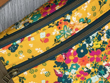 Load image into Gallery viewer, Golden Yellow Flower Print fabric with Mocha Vinyl Accent Large Fanny Pack with Caramel cotton Webbing  and Brass Hardware close up of brass hardware and zipper pull