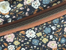 Load image into Gallery viewer, close up of  Black multi color flower fabric with Mocha Vinyl  Large Fanny Pack with Caramel cotton Webbing  and Brass Hardware 